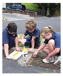 Side image - Kids painting kerbside.