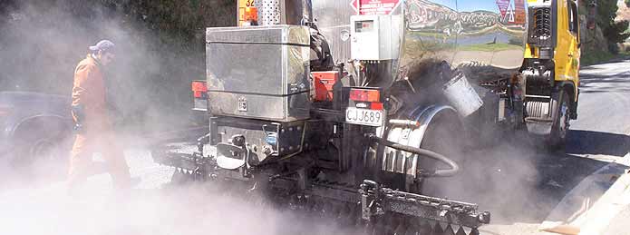 Banner image - Contractors resurfacing a Dunedin road